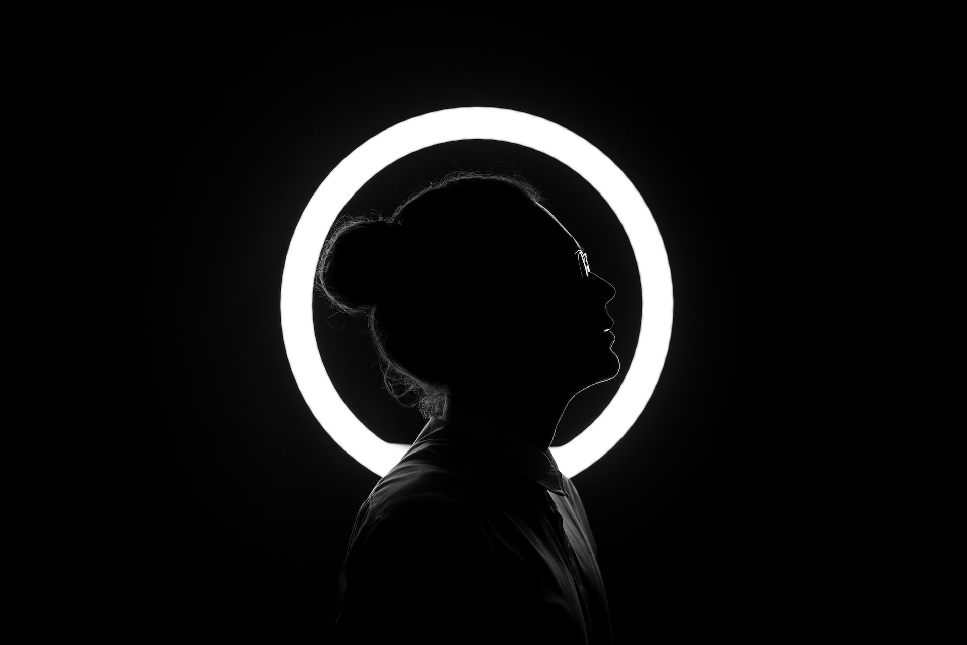 woman standing in the dark with a white circle around the head