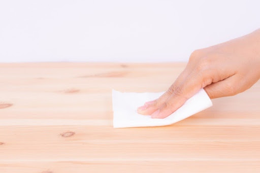 woman wiping wood surface