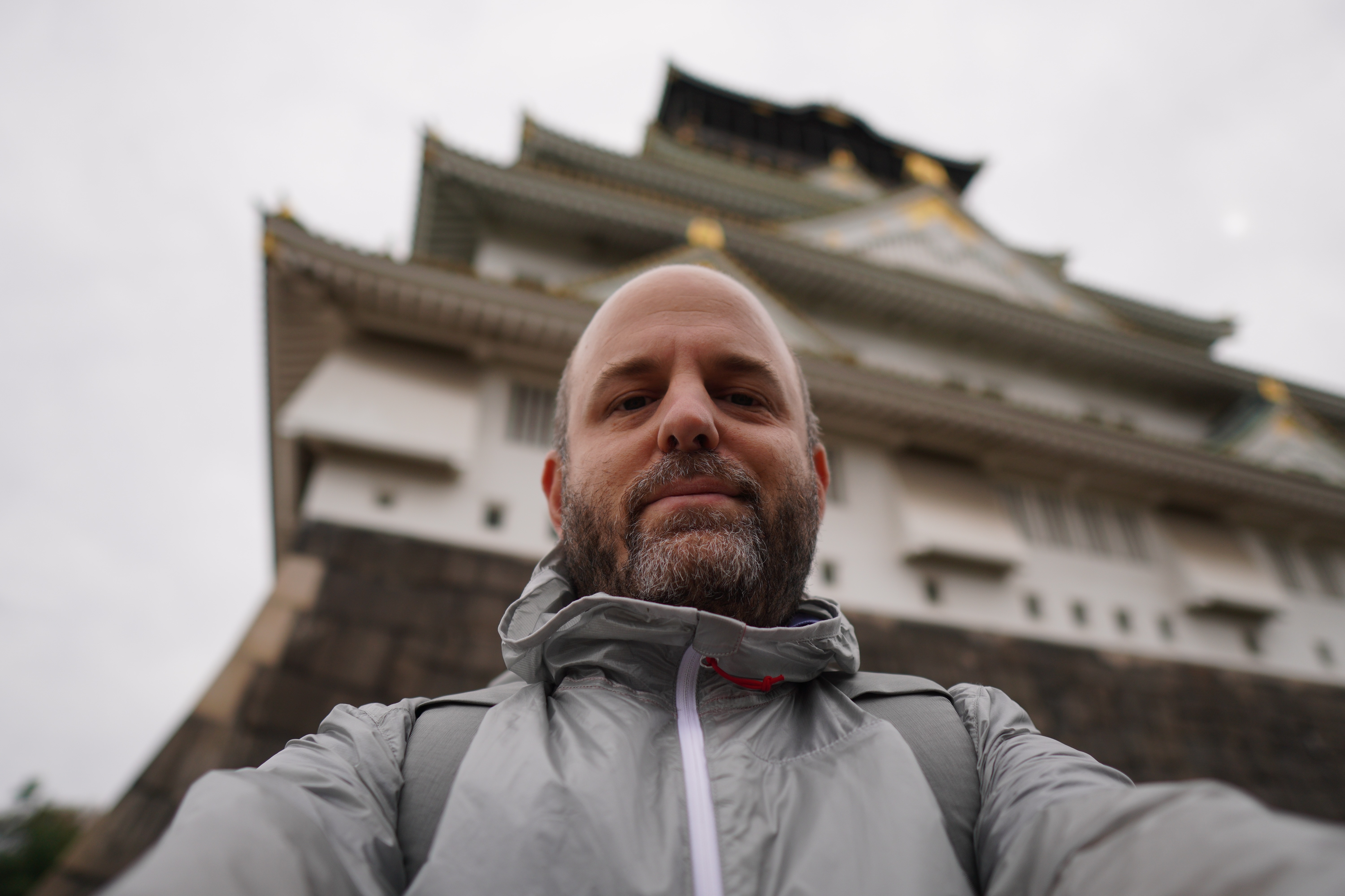 man taking a selfie in front of a building