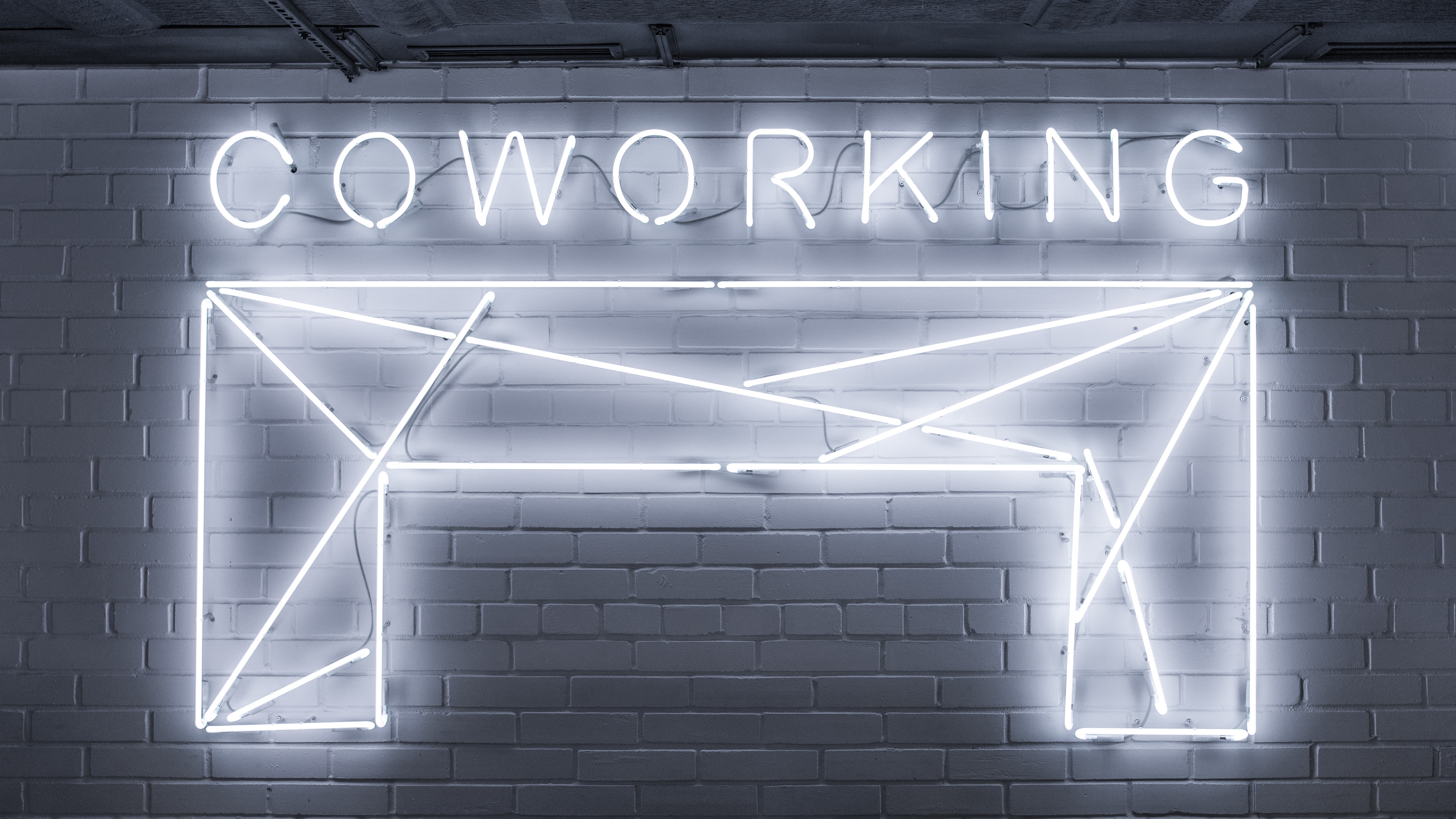 a neon sign "coworking"