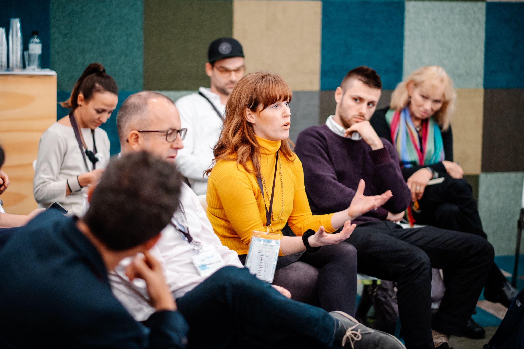 a woman in the crowd at a conference asking a question