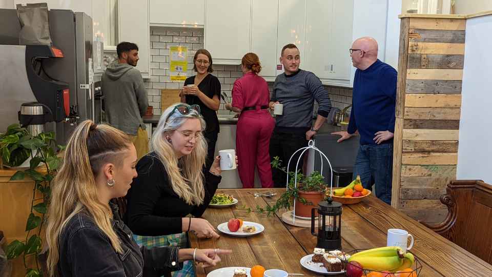 people eating and talking in a coworking kitchen
