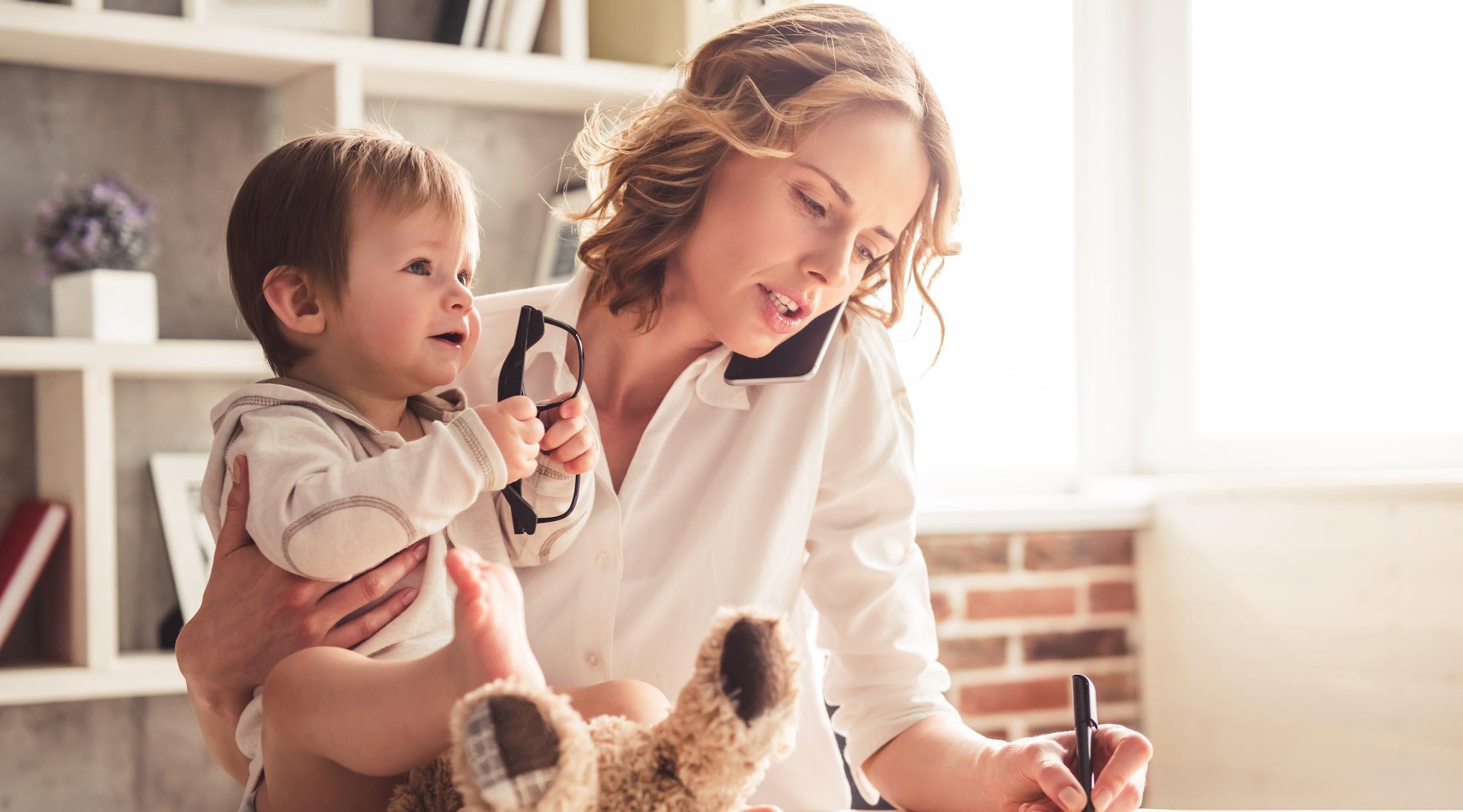 woman talking on the phone and holding a baby
