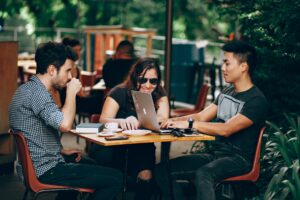 a group of people out for a coffee, laptop on table
