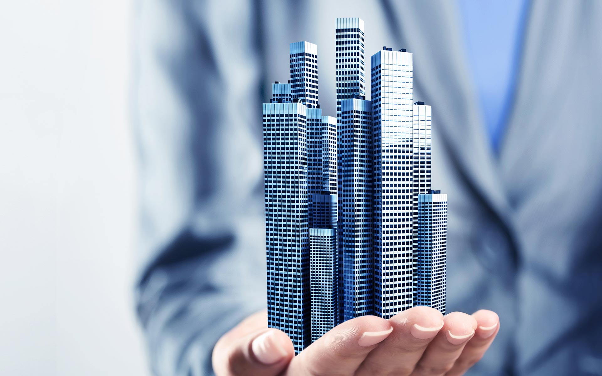 man holding in his has a model of buildings