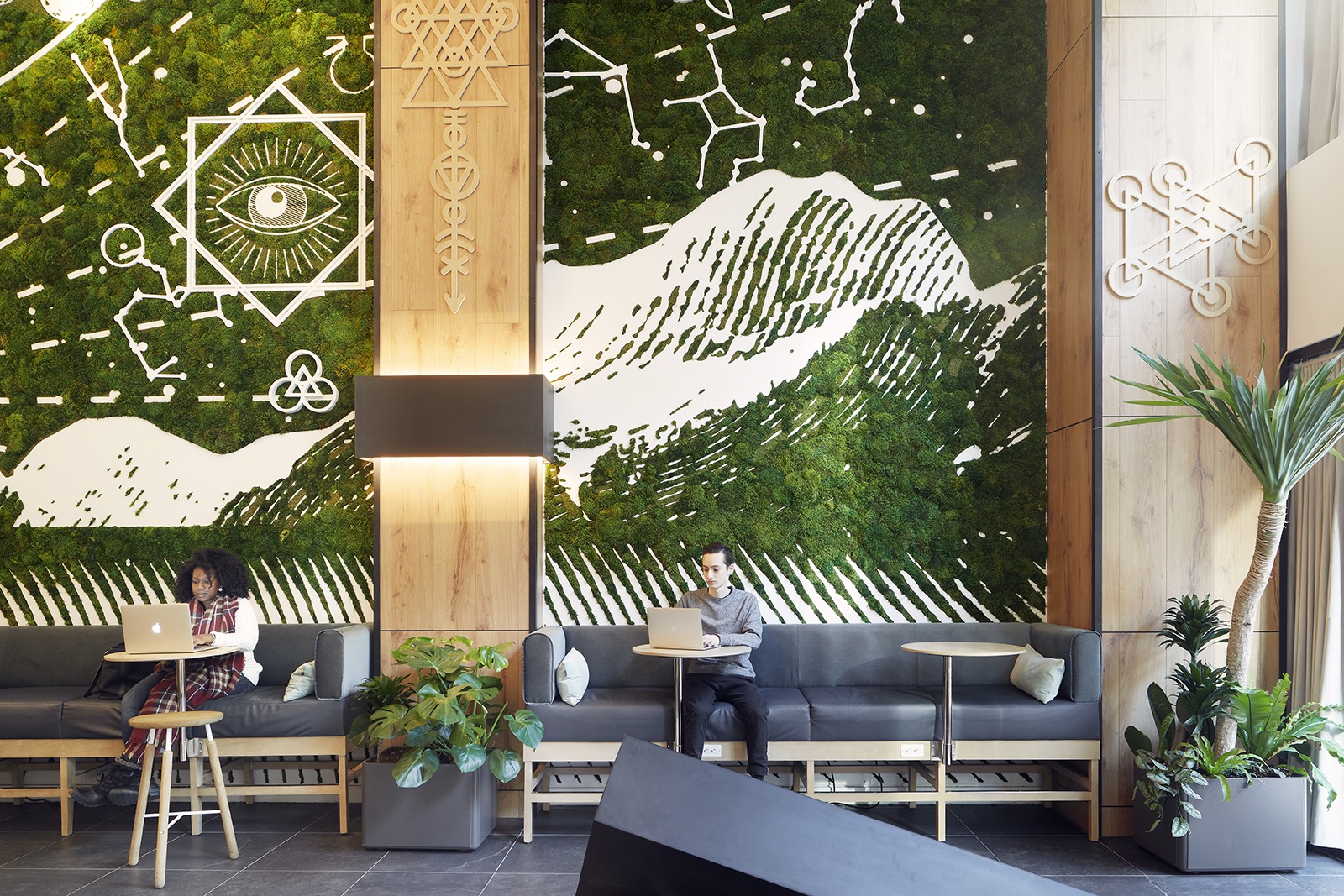 people working from a coworking office with lots of green plants