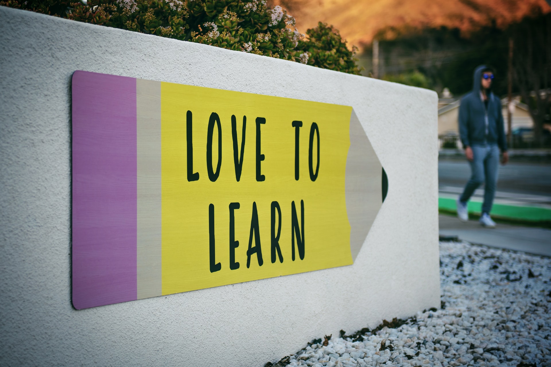 a sign in a shape of a pencil "love to learn"