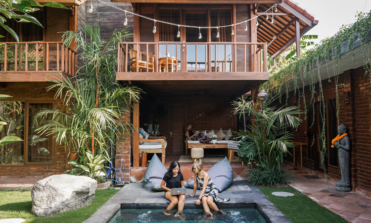 women working from a coworking space with a swimming pool