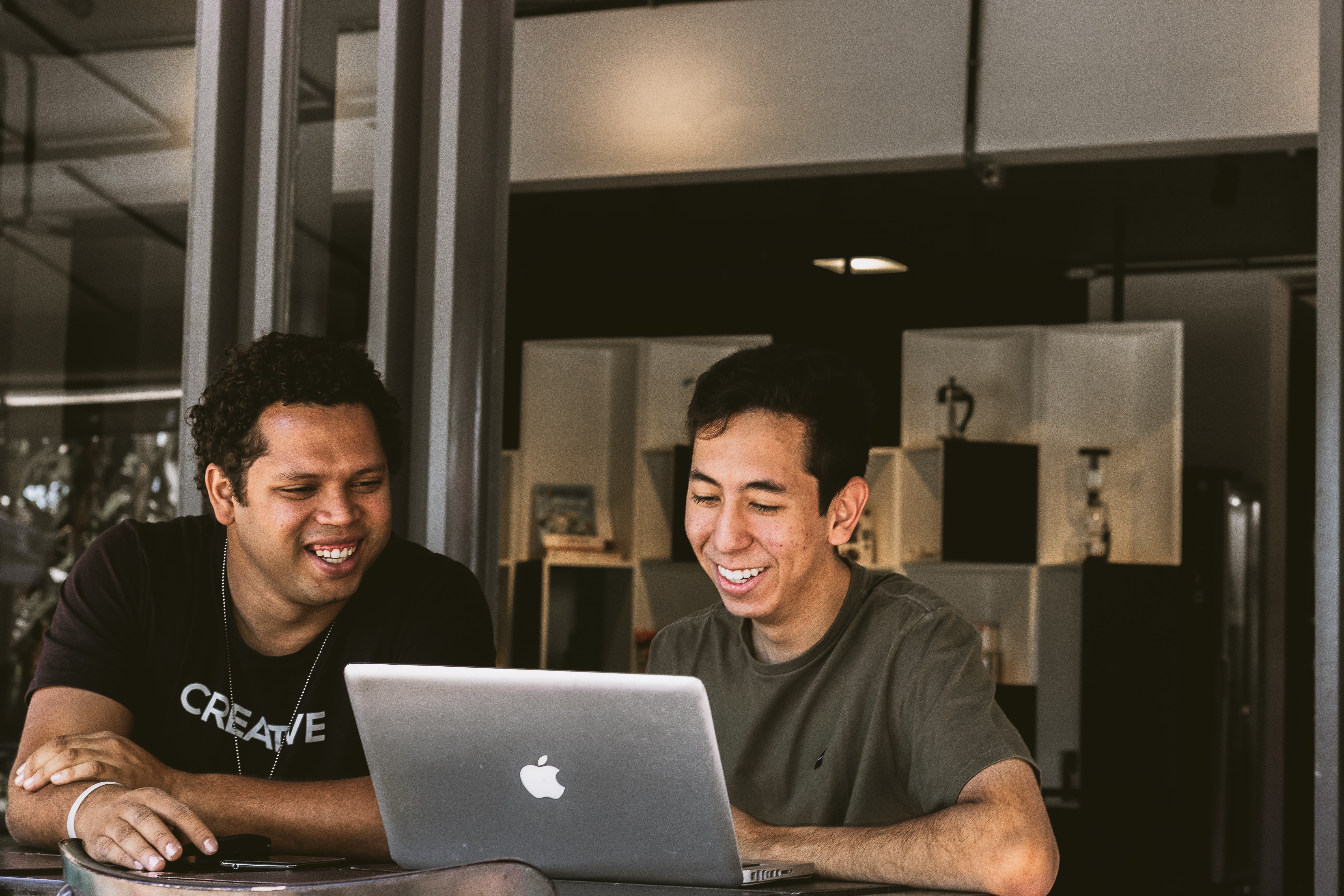 two men looking at something on a laptop