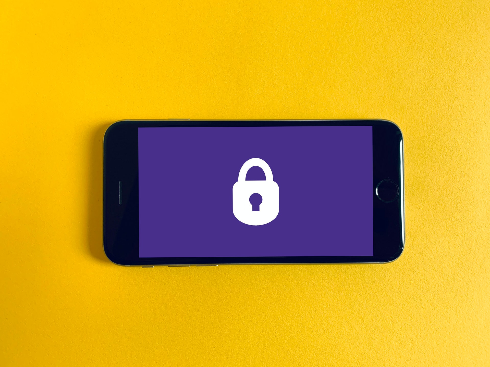 a smartphone with a keylock and a purple background