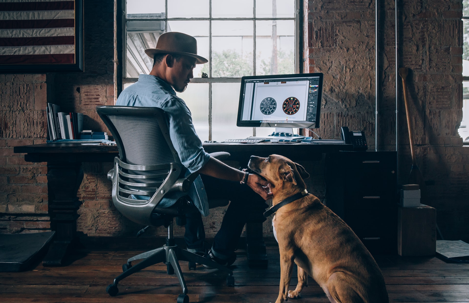 man petting a dog while working