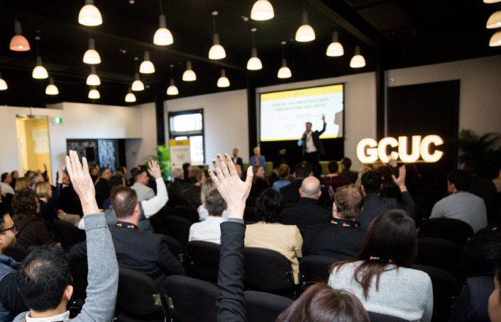 a speech at gcuc event, people raising hands