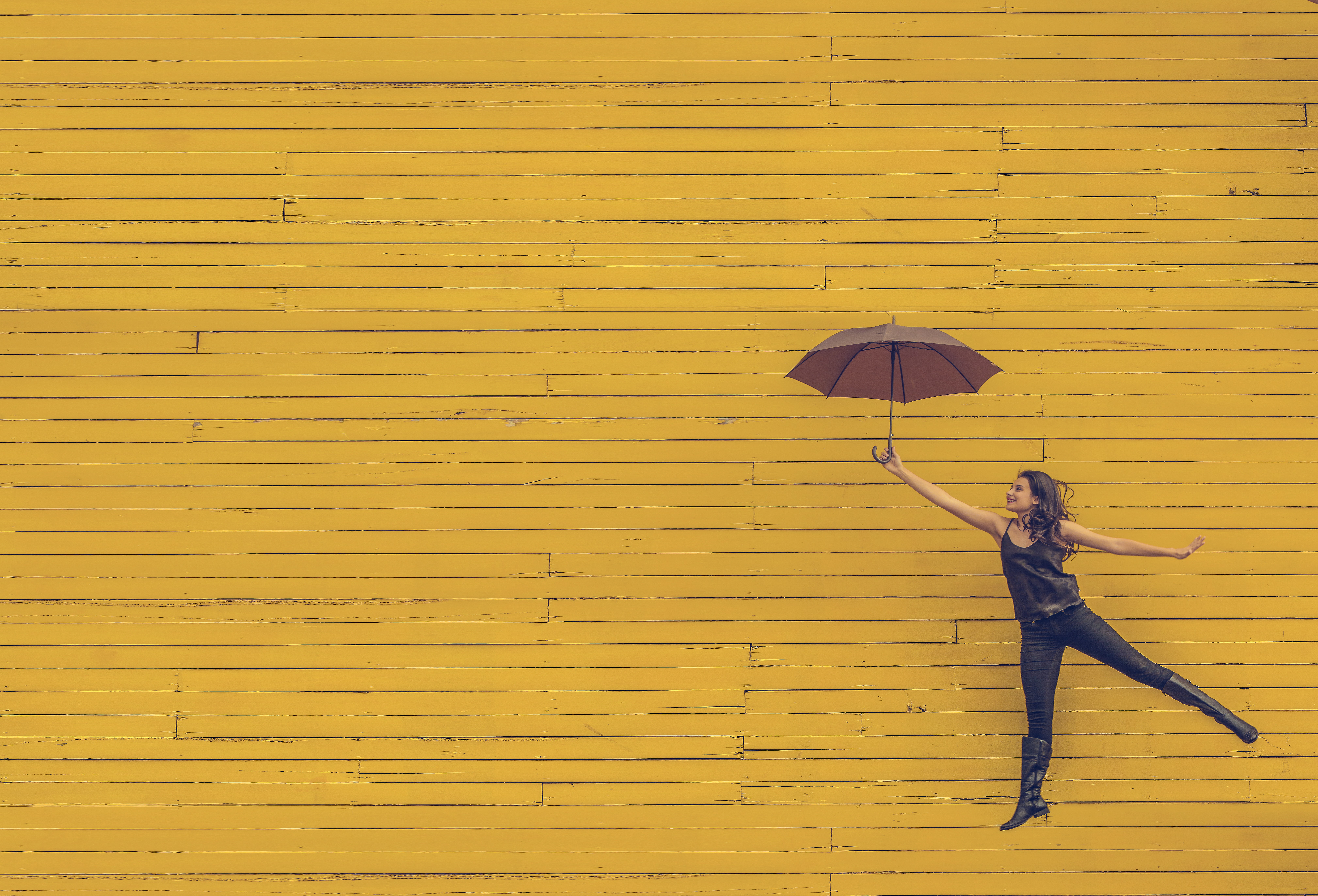 woman holding an umbrella on a yellow background