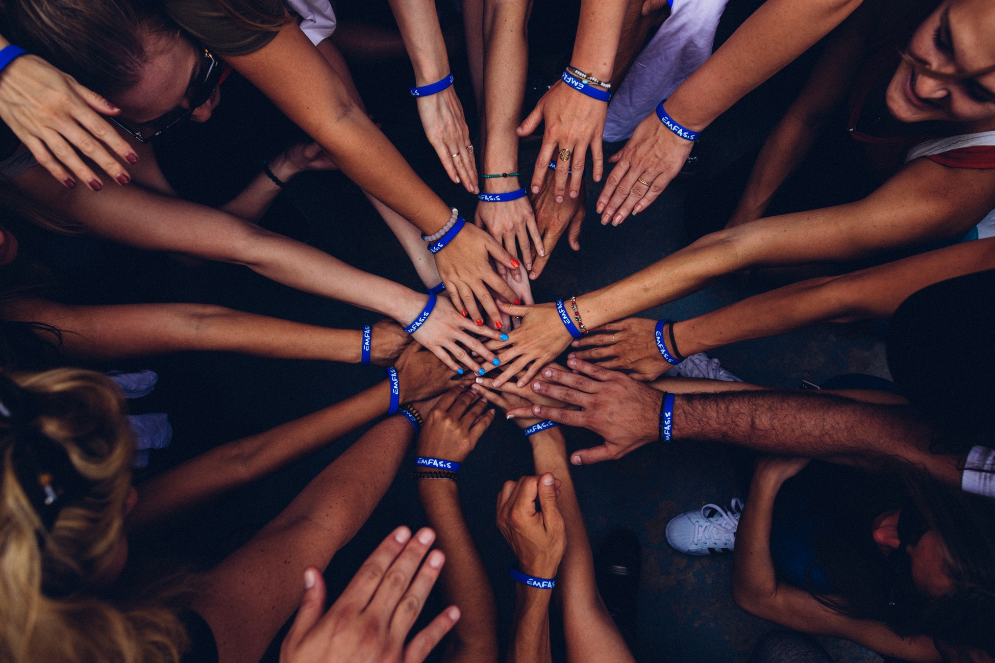 people in a circle, stacking hands