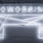 a neon sign on a brick wall "coworking"