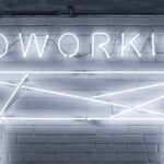 a neon sign on a brick wall "coworking"