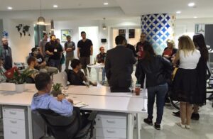 people gathered in office for a celebration, food and drinks on tables
