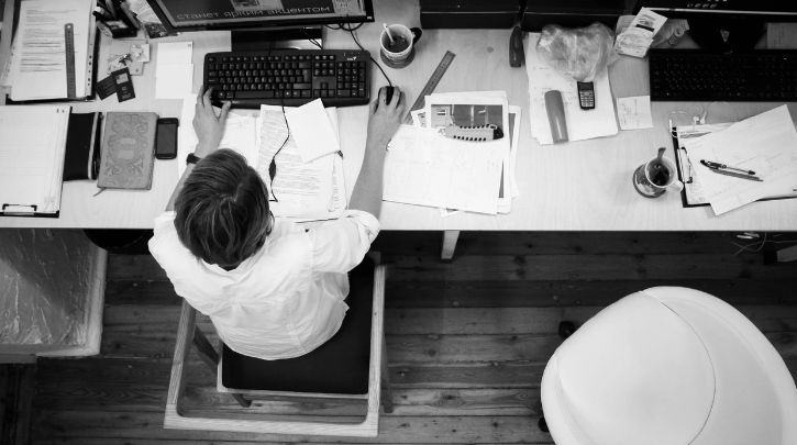 black and white photo taken from above of someone at a desk