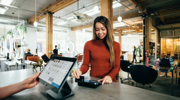 woman making a payment in a cafe with a digital system