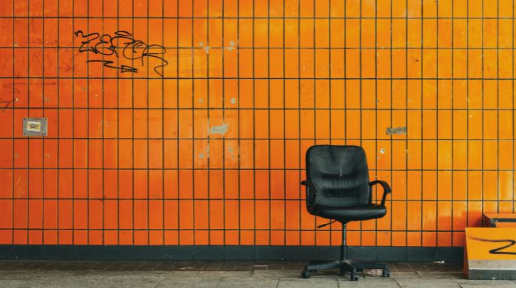an empty office swivel chair against a wall